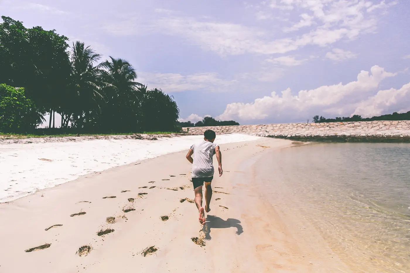 Coureur sur une plage au bord de l'eau